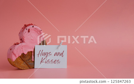 Birthday Valentine's day HUGS AND KISSES wishes saying caption on greeting card Delightful heartshaped pastry croissant treat, beautifully topped with colorful frosting galore. Copy space. Food 125847263