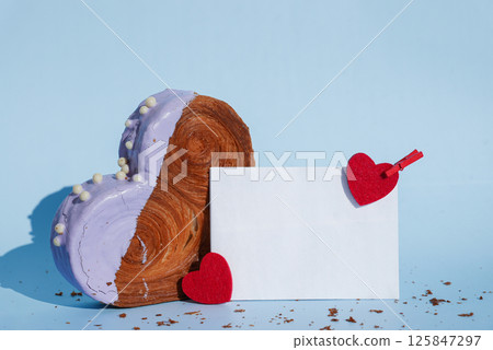 Empty paper note card template mock up Heart shaped blueberry flavor croissant on blue background with copy space. Puff pastry new trendy sweet dessert bakery. Creamy dough 125847297