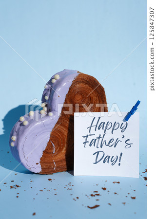 Happy Father's Day saying caption on greeting card Delicious fresh croissant topped with colorful flavor Ganache. Creation unique heart shape bakery. Puff pastry holiday love gift present idea 125847307