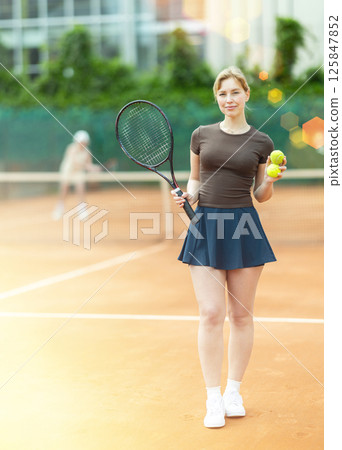 Young woman posing on tennis court Young woman posing on tennis court 125847852