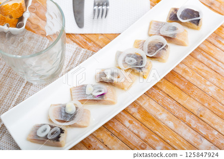 Appetizing herring fillet with onion on top 125847924