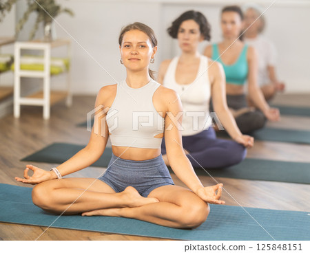 Yoga woman making yoga meditation in lotus pose in fitness studio Yoga woman making yoga meditation in lotus pose in fitness studio 125848151