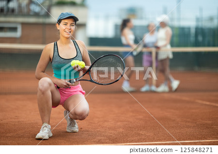 Young woman posing on tennis court Young woman posing on tennis court 125848271