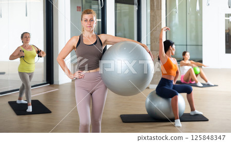 Woman doing exercises with pilates ball at gym 125848347