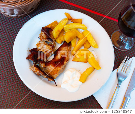 Fried juicy pork with boiled potatoes served on plate 125848547