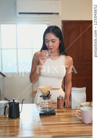 Beautiful woman enjoying the aroma of fresh coffee during a peaceful morning routine 125848652