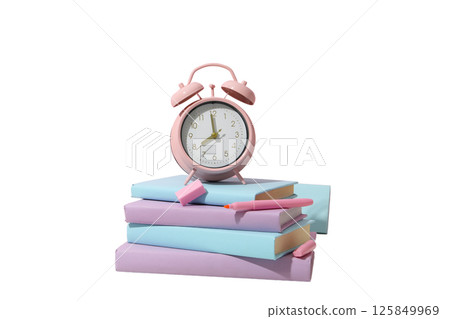 An alarm clock sits on top of stacked books, signaling study time, isolated on white An alarm clock sits on top of stacked books, signaling study time, isolated on white 125849969