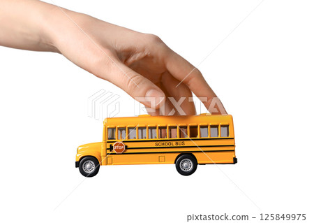 Hand is holding a toy school bus, representing school activities, isolated on white 125849975