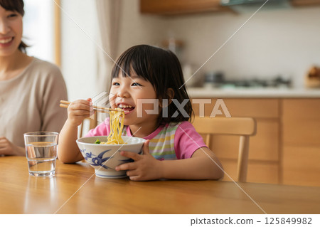 Girls eating noodles 125849982