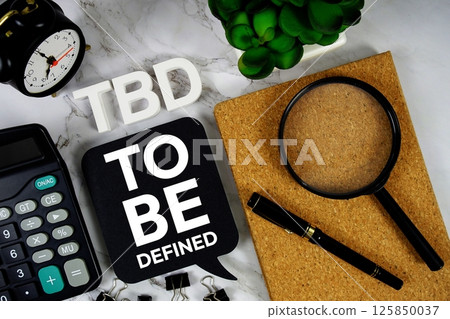 TBD - To Be Defined acronym with alarm clock and magnifying glass, business concept background TBD - To Be Defined acronym with alarm clock and magnifying glass, business concept background 125850037