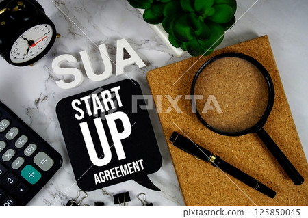 SUA - Start Up Agreement acronym with calculator, alarm clock and magnifying glass, business concept background 125850045