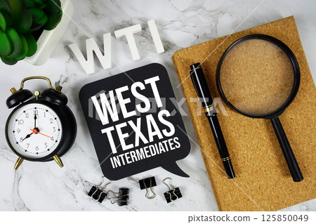 WTI - West Texas Intermediate acronym with alarm clock and magnifying glass, business concept background 125850049
