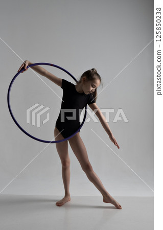 A girl in a swimsuit and a dress shows beautiful athletic elements on a white background. Ballet, rhythmic gymnastics, fabric, aesthetics, grace. High quality photo A girl in a swimsuit and a dress shows beautiful athletic elements on a white background. Ballet, rhythmic gymnastics, fabric, aesthetics, grace. High quality photo 125850238