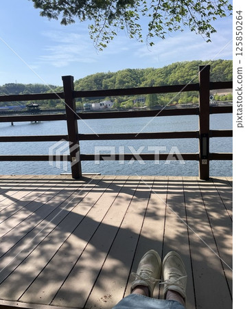 A relaxing afternoon on the lakeside wooden deck A relaxing afternoon on the lakeside wooden deck 125850264