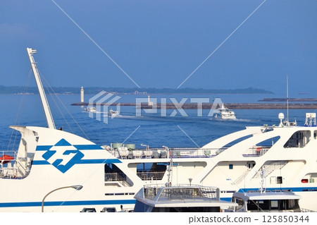 駛離石垣港的船隻和停泊的渡輪「與那國號」(背景為竹富島) 駛離石垣港的船隻和停泊的渡輪「與那國號」(背景為竹富島) 125850344
