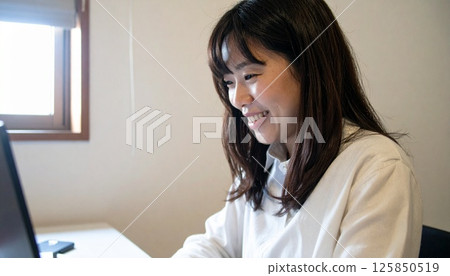 Woman operating a personal computer 125850519