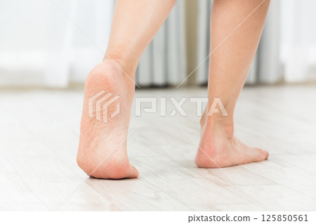A young woman walking barefoot. 125850561
