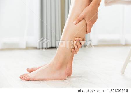 一位女士正在按摩雙腿。 一位女士正在按摩雙腿。 125850566