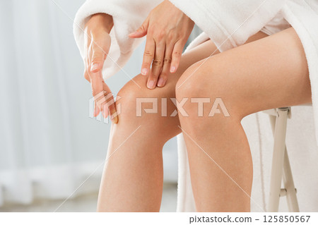 Young Asian woman is doing skin care for her knee. 125850567