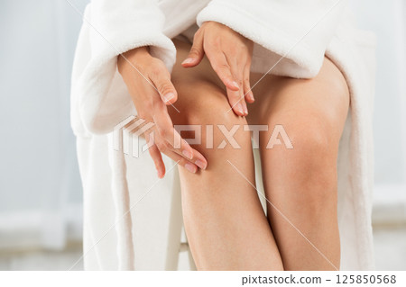 Young Asian woman is doing skin care for her knee. 125850568