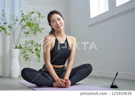 A woman in her twenties enjoying online yoga 125850636