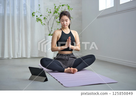 A woman in her twenties enjoying online yoga A woman in her twenties enjoying online yoga 125850849