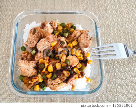 Deliciously prepared chicken and vegetable stir-fry served over fluffy white rice in glass container meal prep concept Deliciously prepared chicken and vegetable stir-fry served over fluffy white rice in glass container meal prep concept 125851901