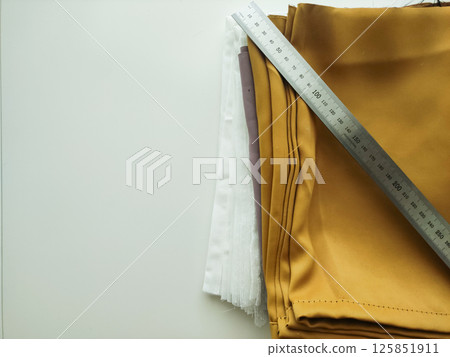 Stacked fabric swatches in various colors with measuring ruler showcasing textile diversity and design potential Stacked fabric swatches in various colors with measuring ruler showcasing textile diversity and design potential 125851911