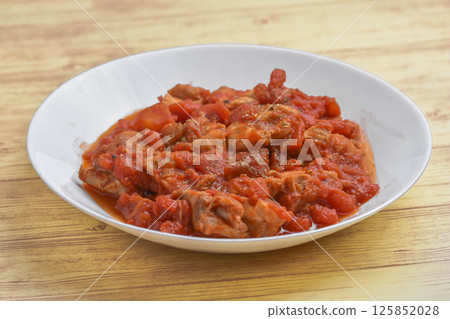 Chicken thigh stewed in tomato sauce 125852028
