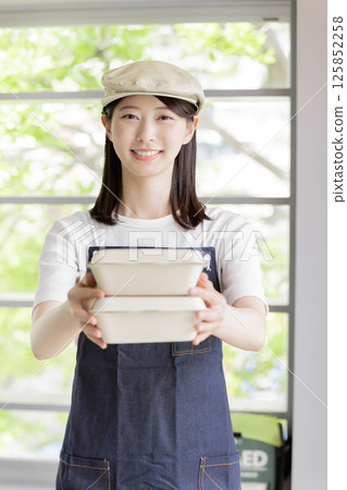 一位女咖啡服務生正在送餐 一位女咖啡服務生正在送餐 125852258