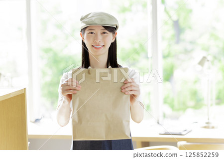 一位女咖啡服務生正在送餐 一位女咖啡服務生正在送餐 125852259