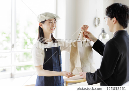 咖啡館的一位女店員在櫃檯向顧客下訂單 125852261