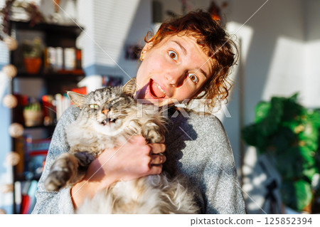 portrait young woman hugging gray fluffy domestic cat portrait young woman hugging gray fluffy domestic cat 125852394