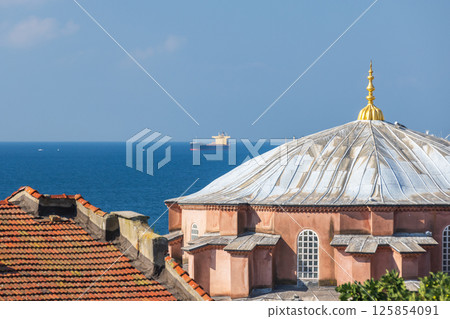 A beautiful domed mosque with a scenic view of Bosporus and a ship 125854091