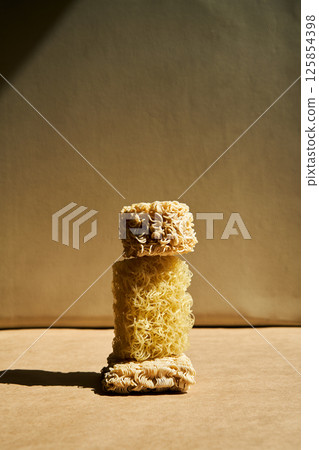 Creative food composition of ramen noodles over beige. 125854398