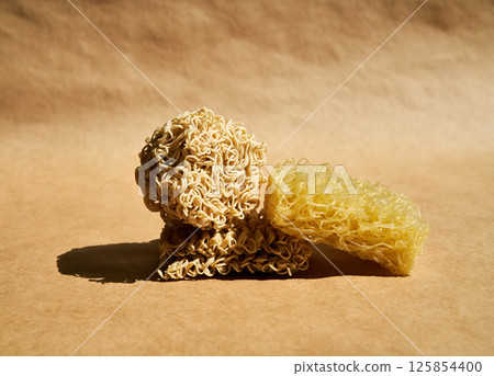 Creative food composition of ramen noodles over beige. Creative food composition of ramen noodles over beige. 125854400