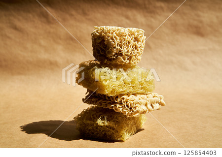 Creative food composition of ramen noodles over beige. 125854403