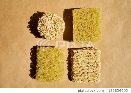 Various dry instant noodle blocks over brown background 125854405