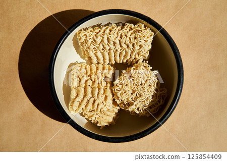 Dry instant noodles inside ceramic bowl 125854409