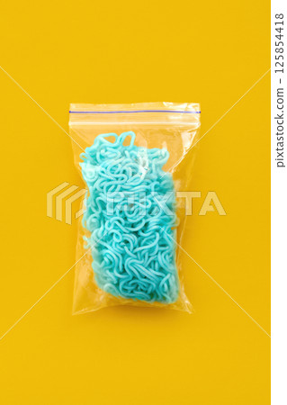 Bright blue noodles inside transparent plastic bag Bright blue noodles inside transparent plastic bag 125854418