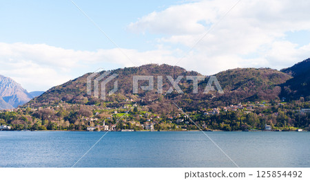 Wide panoramic scene of mountains and Como lake 125854492