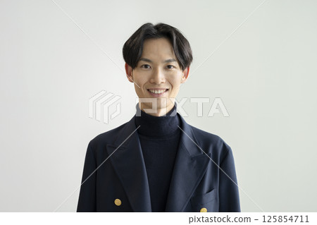 一位 30 多歲的男子對著鏡頭微笑，白色背景，肖像 125854711