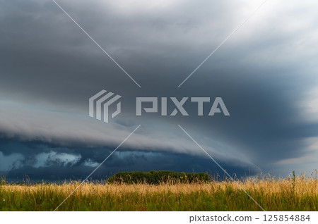 WEATHER - Dramatic Dark Rain Clouds over Fields and Country Road. Shelf Cloud, Supercell, Cyclone, Storm, Lithuania WEATHER - Dramatic Dark Rain Clouds over Fields and Country Road. Shelf Cloud, Supercell, Cyclone, Storm, Lithuania 125854884