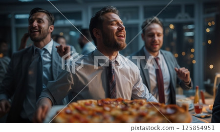 Office workers having a pizza party in the office late at night 125854951