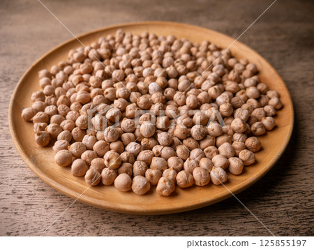 Raw Chickpeas on a rustic wooden table. Dry chickpea background close up. Chickpea legumes seed background. Raw Chickpeas on a rustic wooden table. Dry chickpea background close up. Chickpea legumes seed background. 125855197
