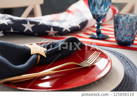 American table setting for USA Independence Day. Festive dinner decorated in USA national flag colors white, red and blue. Close up. 125856119