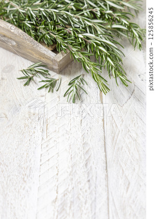 Fresh green rosemary sprigs in a tray on white rustic table closeup. Aromatic herb for culinary Fresh green rosemary sprigs in a tray on white rustic table closeup. Aromatic herb for culinary 125856245