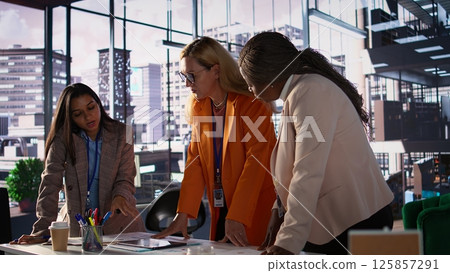 Ambitious woman CEO in a meeting shares ideas with her staff, plan a business expansion strategy to achieve success. Diverse businesswomen in leadership positions strategize for growth. Camera B. Ambitious woman CEO in a meeting shares ideas with her staff, plan a business expansion strategy to achieve success. Diverse businesswomen in leadership positions strategize for growth. Camera B. 125857291