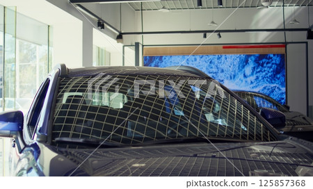 Close up shot of showcased cars with sleek design in showroom waiting to be purchased by interested customers. Modern vehicle models in dealership being promoted for potential clients Close up shot of showcased cars with sleek design in showroom waiting to be purchased by interested customers. Modern vehicle models in dealership being promoted for potential clients 125857368