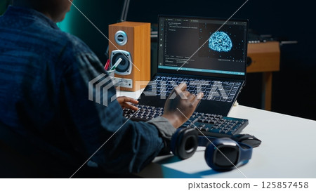 Computer scientist updating artificial intelligence neural networks, writing binary code scripts. Remote worker in apartment office uses digital device programming to upgrade AI, camera A Computer scientist updating artificial intelligence neural networks, writing binary code scripts. Remote worker in apartment office uses digital device programming to upgrade AI, camera A 125857458